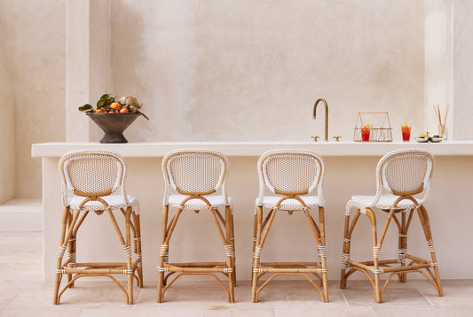 Four rattan bar stools in front of a white countertop with a neutral wall background. - Image 2