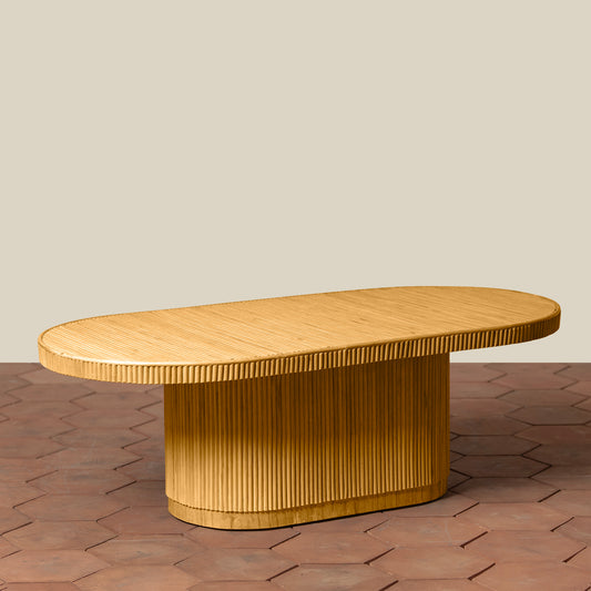 Wooden coffee table with a textured surface on a brick floor.