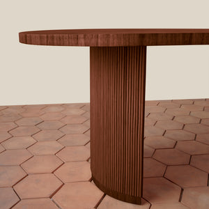 Wooden table with a textured surface on a hexagonal tile floor. - Number 4