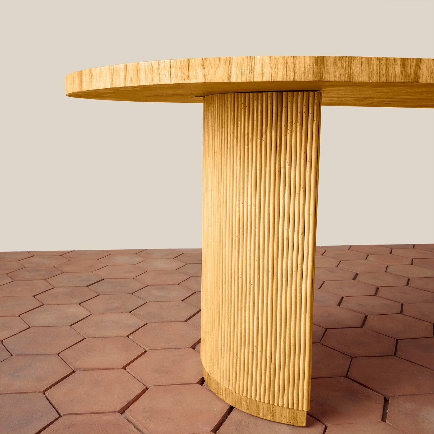 Wooden table with a textured cylindrical base on a hexagonal tile floor.- Number 5