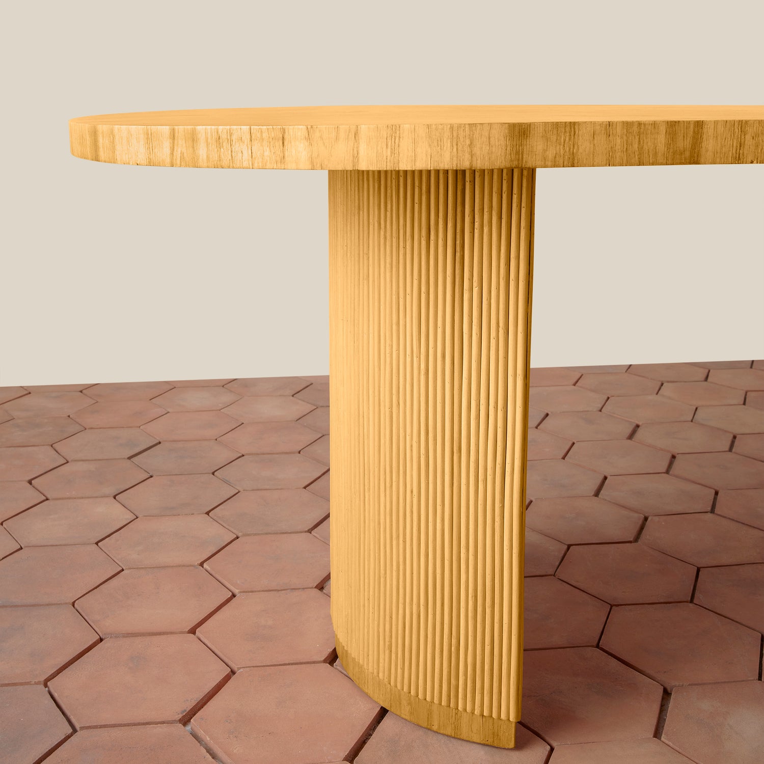 Wooden table with a textured cylindrical base on a hexagonal tile floor.- Number 6