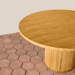 Wooden round table with a textured base on a hexagonal tile floor. - Number 6