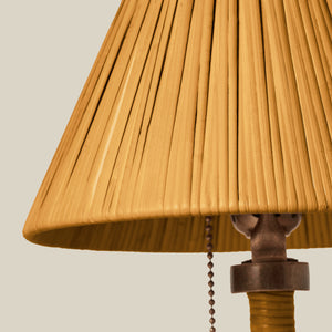 Close-up of a pleated yellow lampshade with a pull chain on a beige background - Number 5