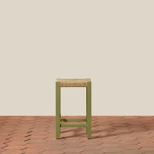 Green stool with woven seat on a wooden floor and beige wall background - Number 14
