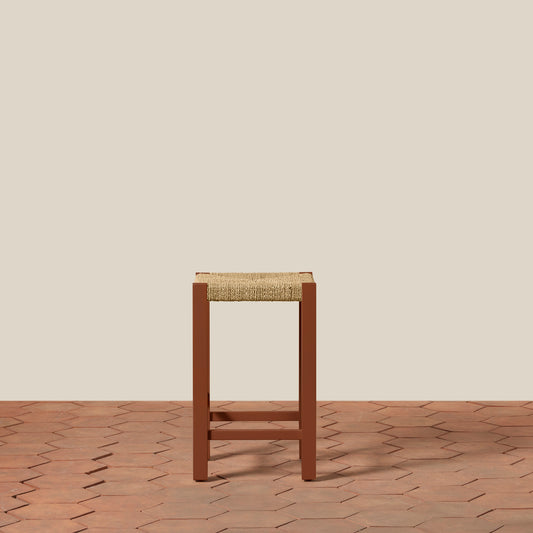 Wooden stool with woven seat on a wooden floor and beige wall background - Image 2