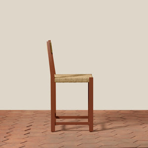 Wooden chair with woven seat on a wooden floor and beige wall - Number 8