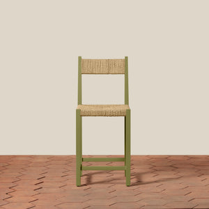 Green chair with woven seat and backrest on a beige wall and wooden floor background - Number 21