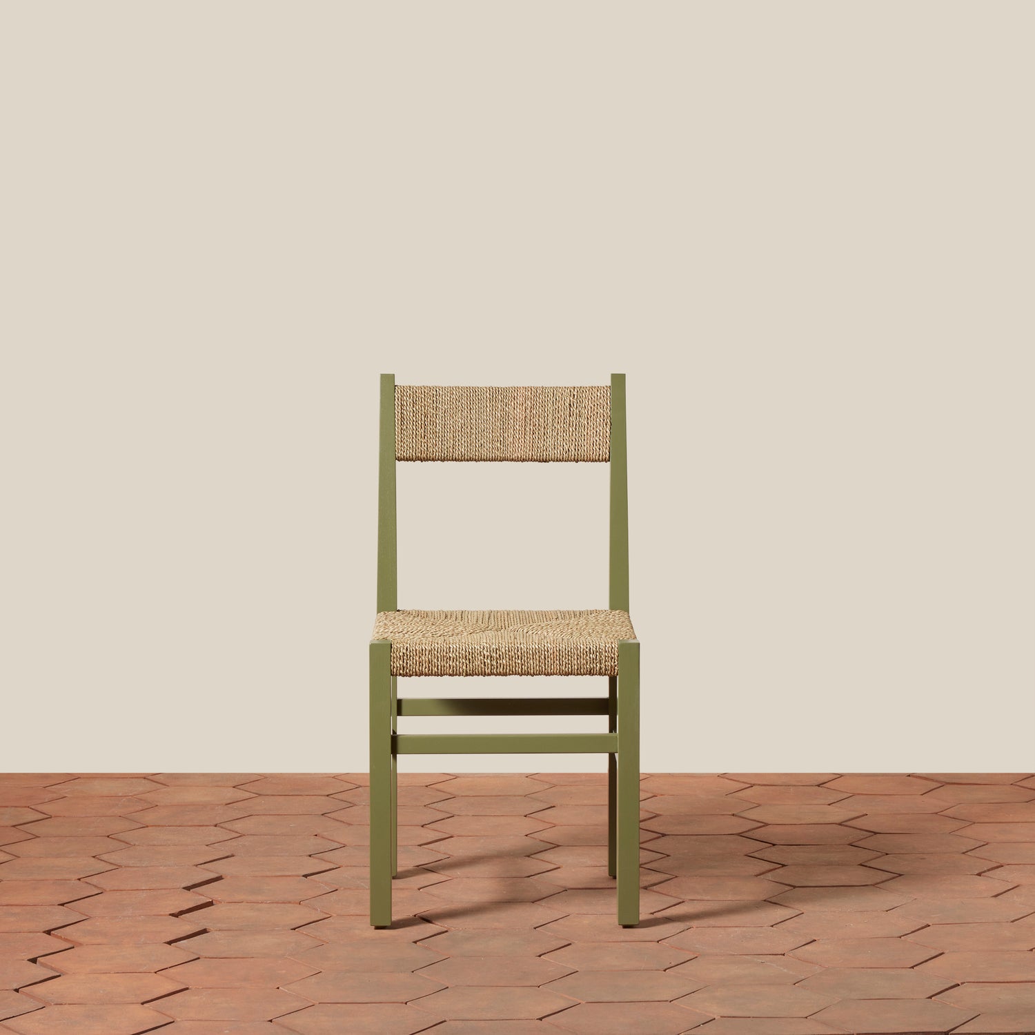 Green chair with woven backrest on a wooden floor and beige wall- Number 23