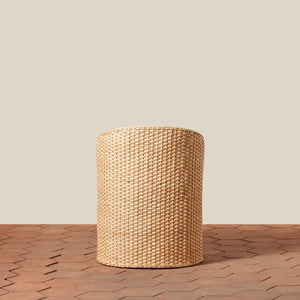 Woven cylindrical stool on a wooden floor with a neutral background - Number 4