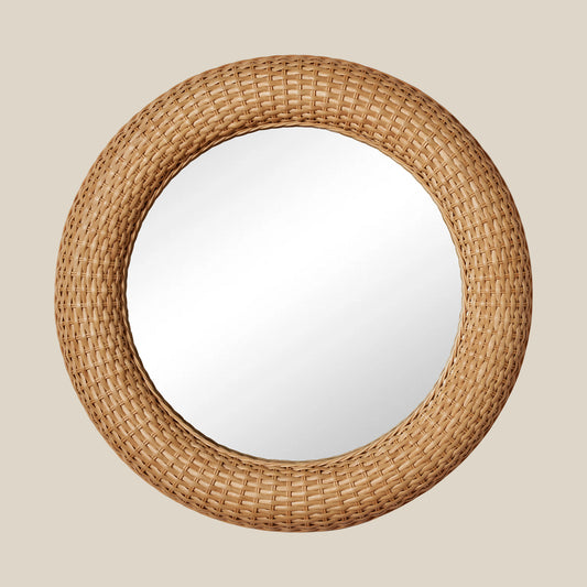Round mirror with a woven rattan frame on a beige background