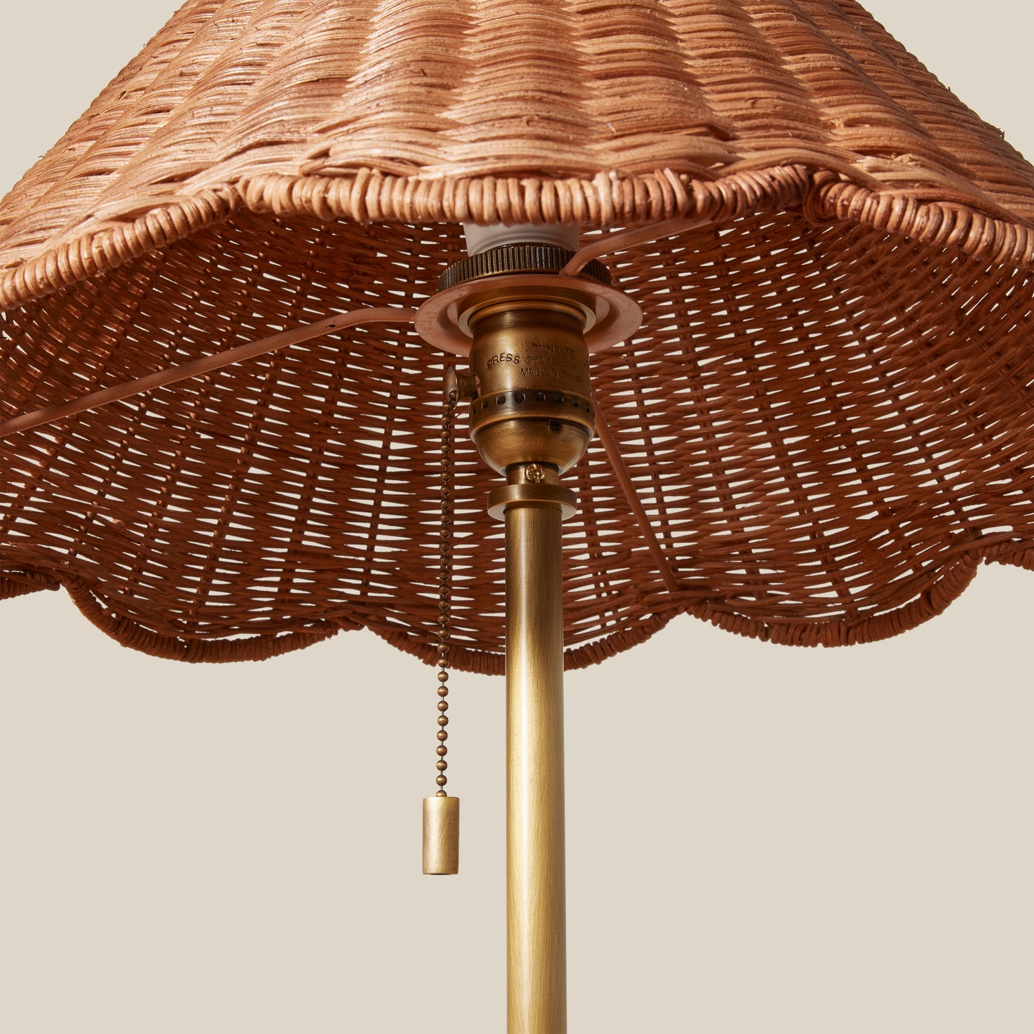 Wicker lampshade with brass fixture on a beige background- Number 4