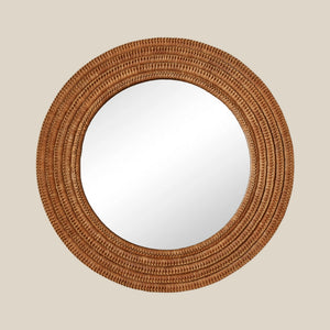Round mirror with a woven brown frame on a beige wall - Number 1
