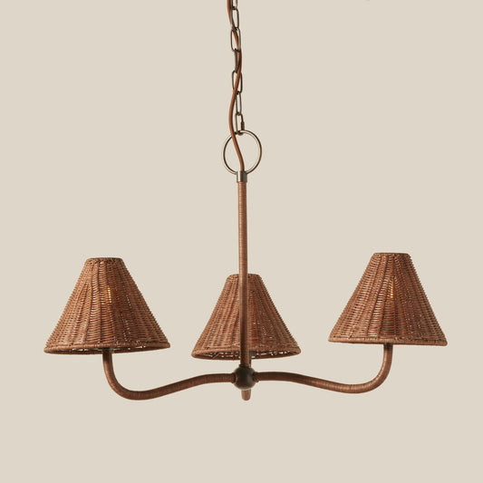 Wicker chandelier with three lampshades on a beige background