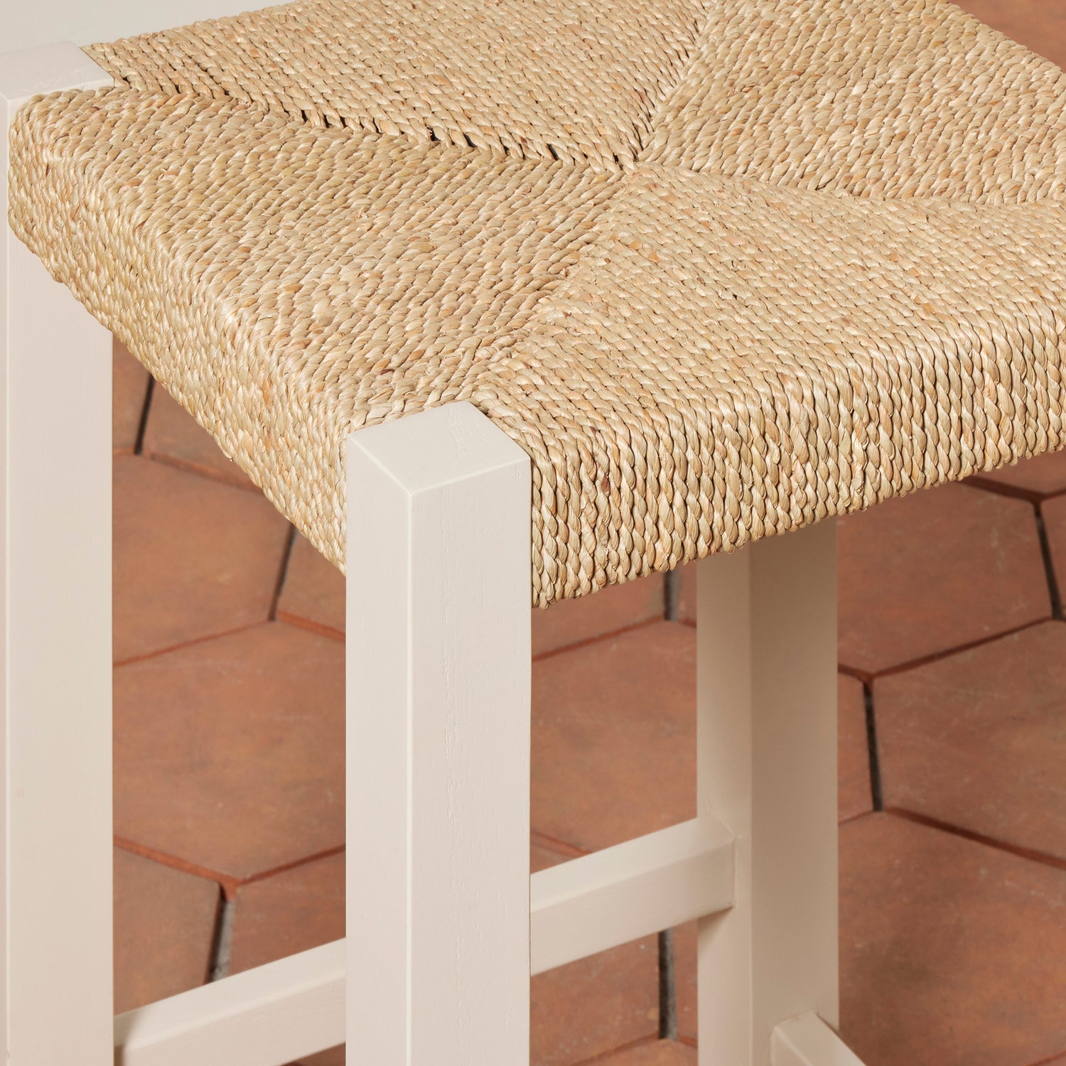 Bar stool with woven seat and white frame on a wooden floor- Number 12