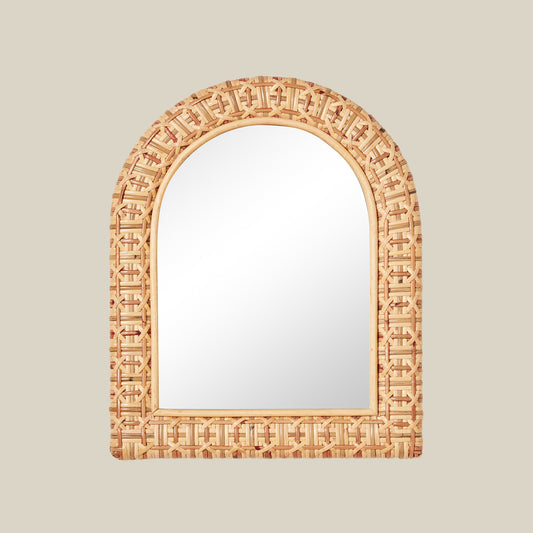 Decorative mirror with an arch-shaped, woven frame on a beige background
