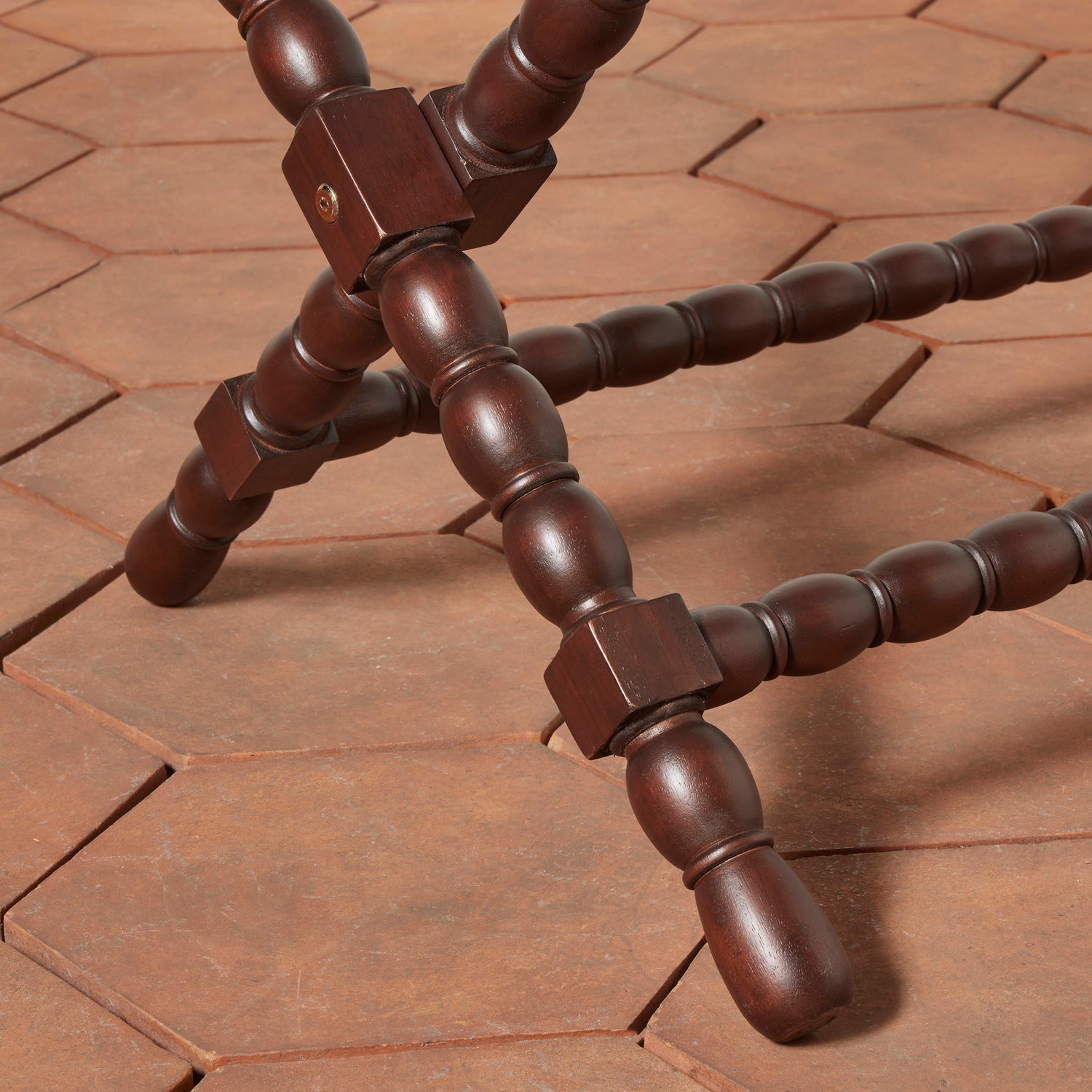 Close-up of a wooden tripod on a brick surface- Number 6