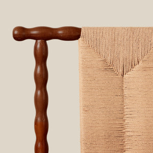 Beige textured blanket draped over a wooden rod against a beige background - Number 7
