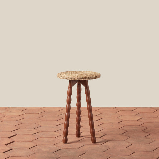 wood stool on tile floor against beige wall