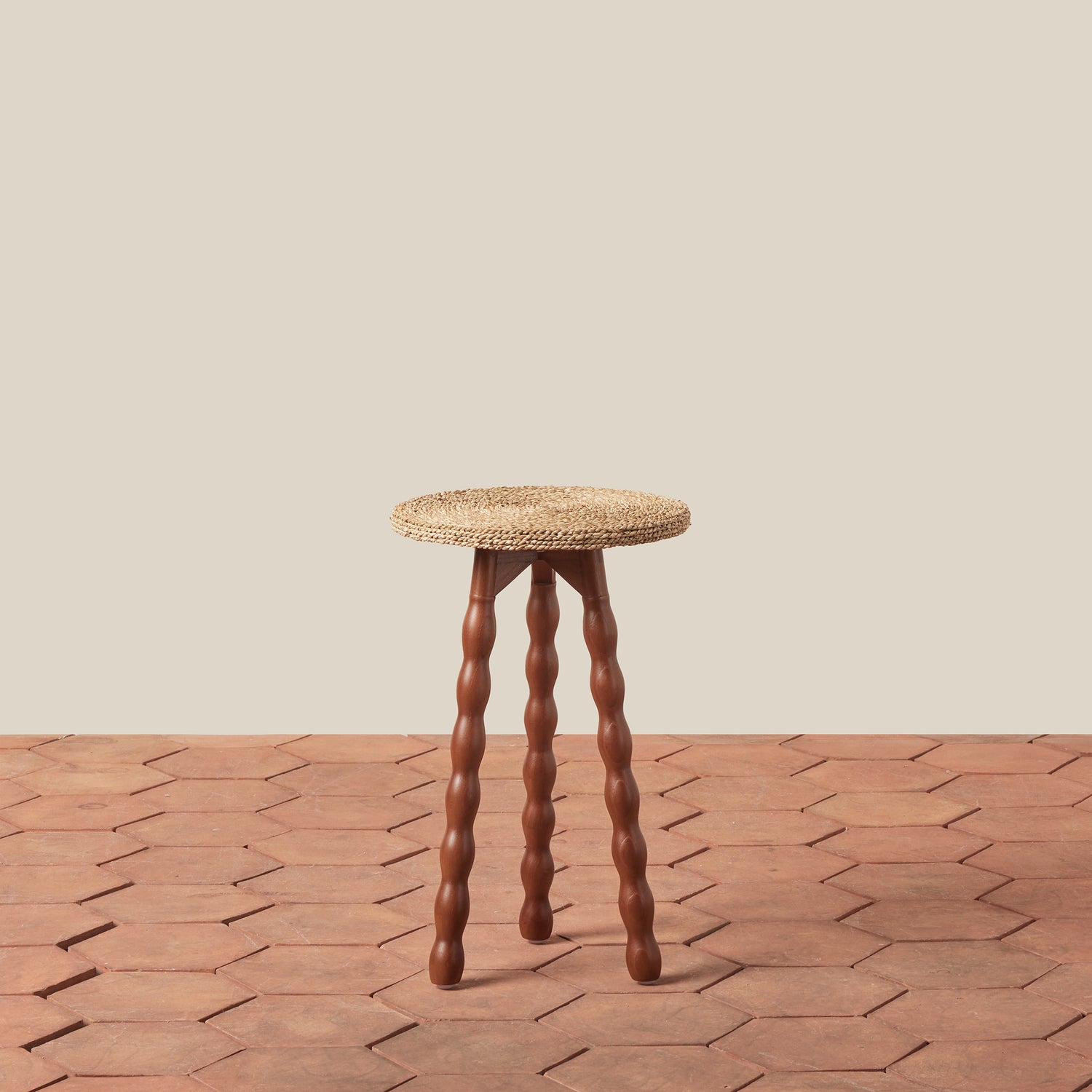 wood stool on tile floor against beige wall- Number 1