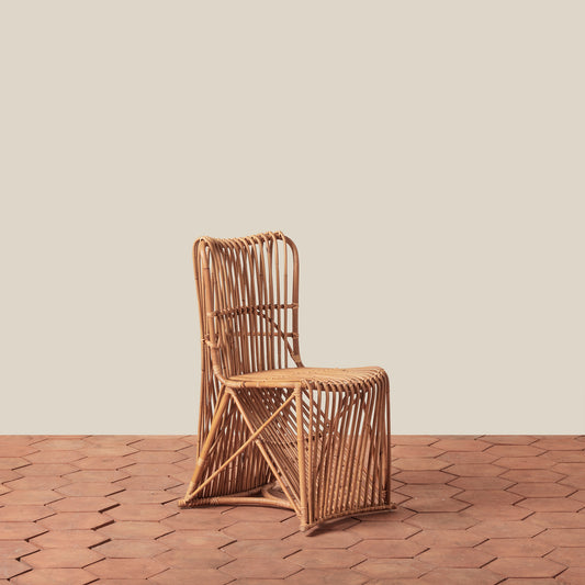 Woven chair on a wooden floor with a beige wall background
