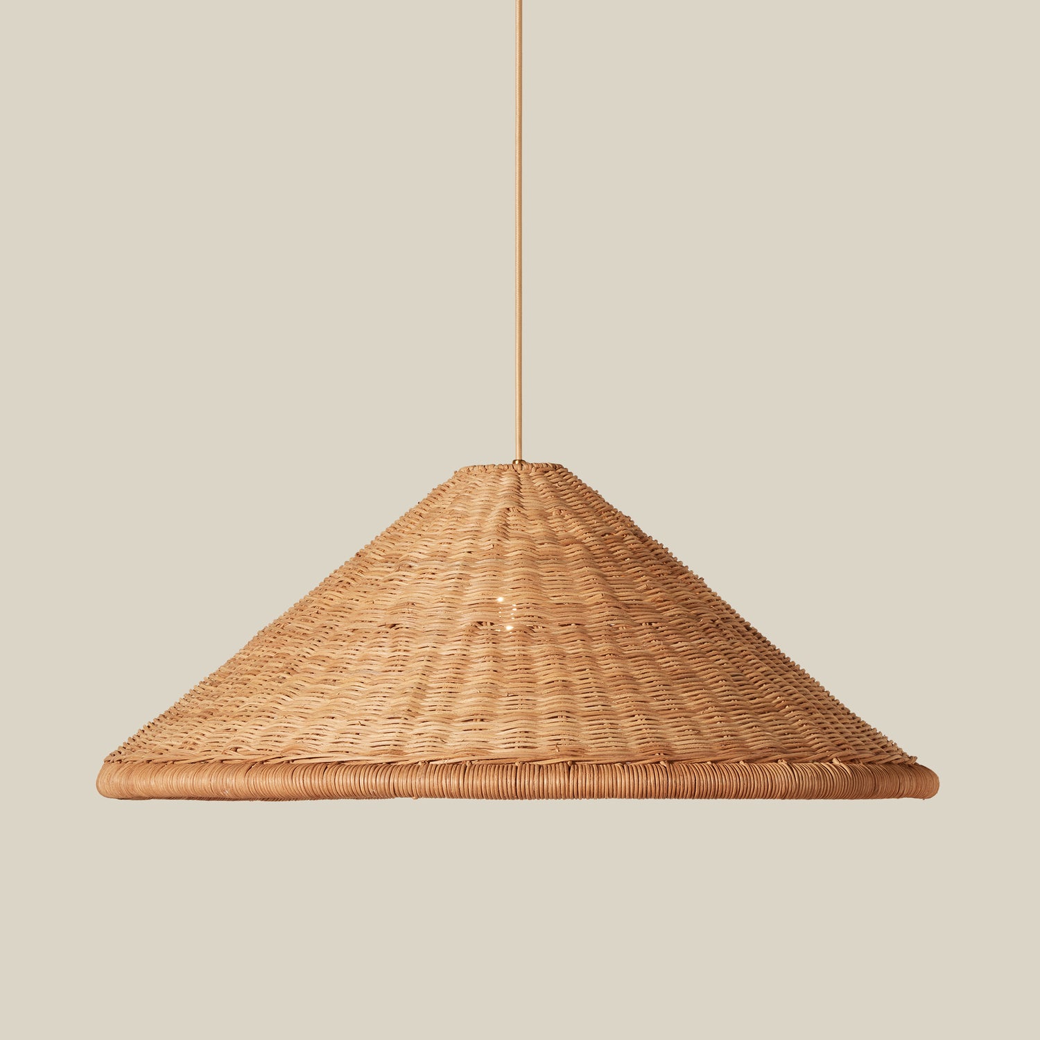 A natural woven rattan pendant light shade with a tapered conical shape, suspended by a thin cord against a solid beige background.- Number 2
