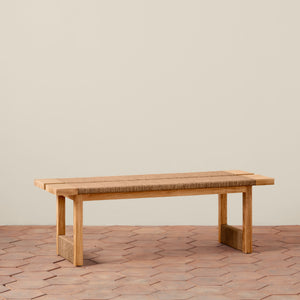 Wooden bench with woven seat on a wooden floor against a beige wall - Number 1