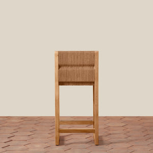 Wooden bar stool with woven seat on a wooden floor and beige wall background - Number 7