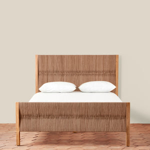 Wooden bed with white bedding against a beige wall - Number 4