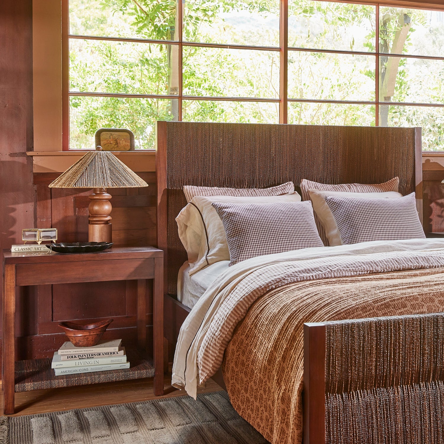 brown side table with lamp on top, next to brown bed against window- Number 2