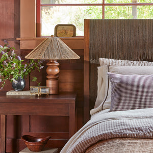 brown bed with blue and white sheets next to brown side table and lamp - Number 2