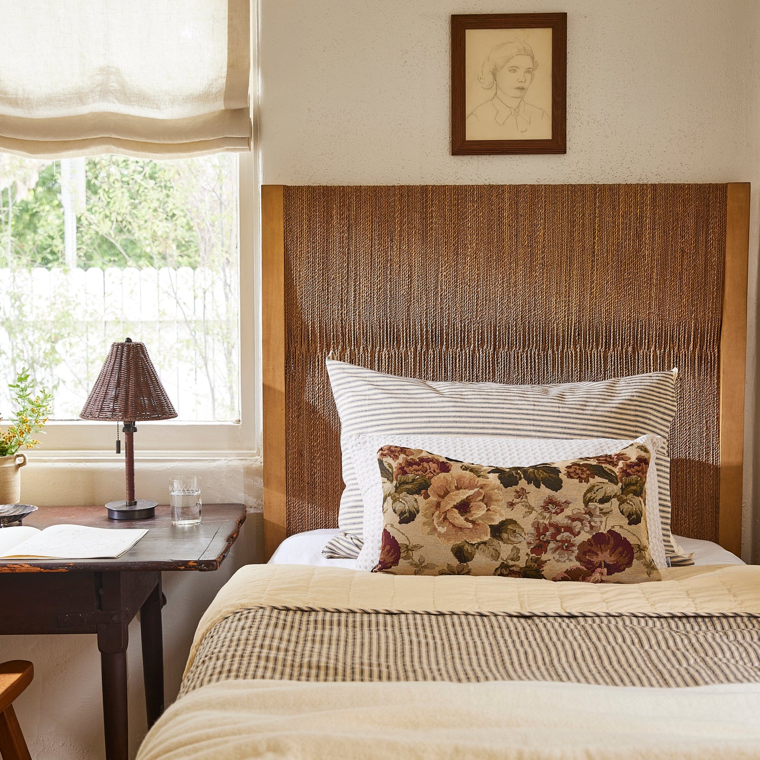 Bedroom with wooden headboard, floral pillow, and lamp on a nightstand.- Number 2