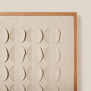 Framed artwork with embossed circular patterns on a textured beige background - Number 5