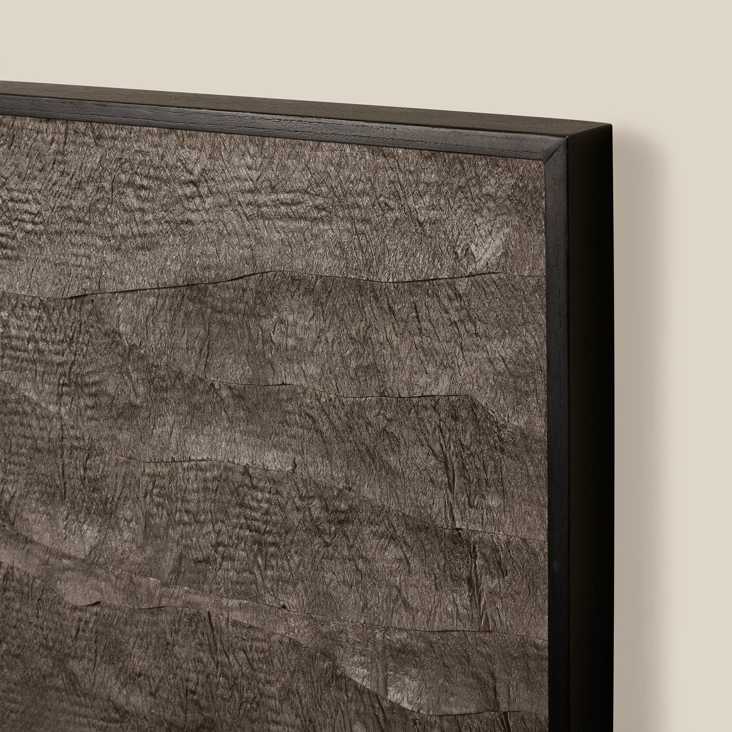 Close-up of a textured wall panel with a black frame on a beige background- Number 3