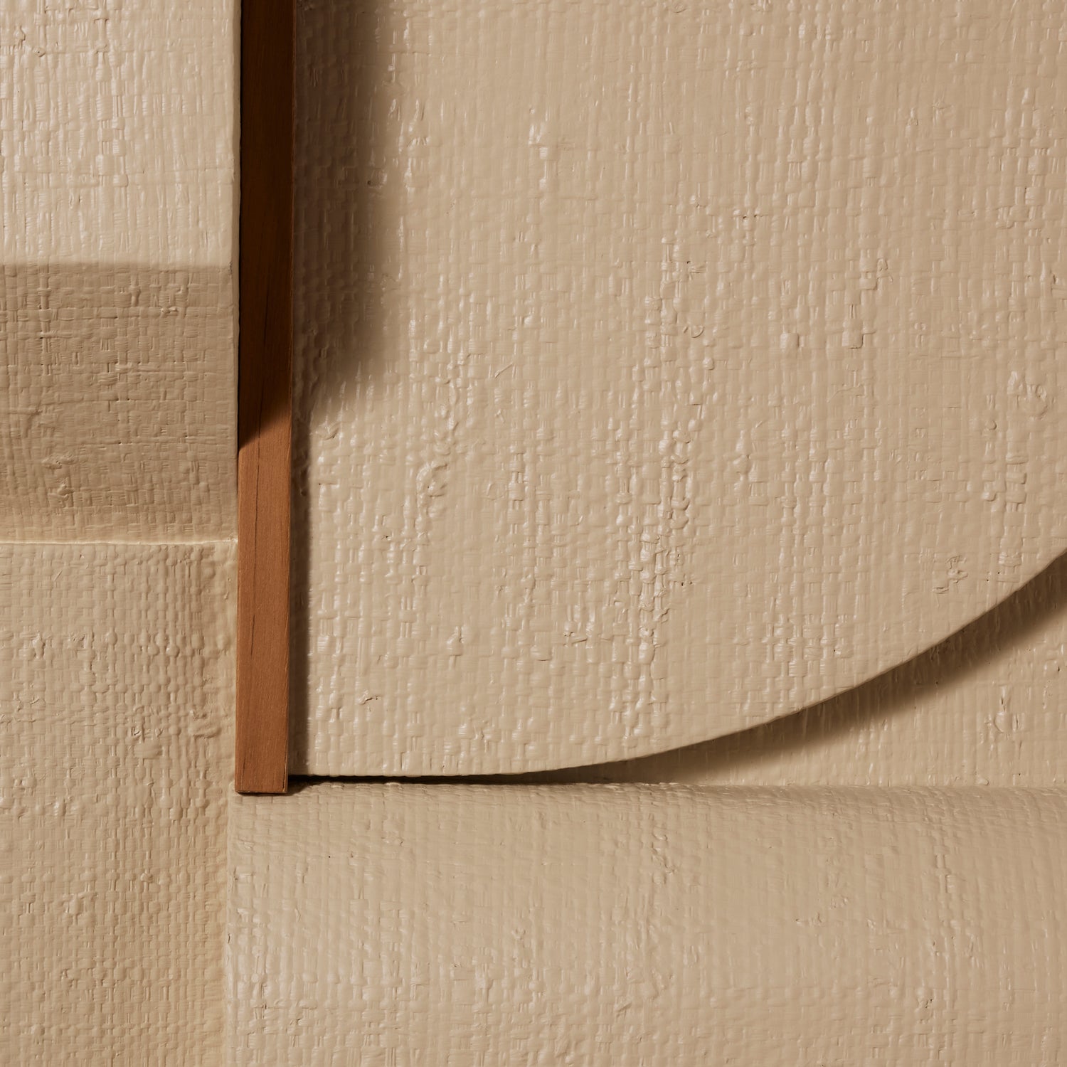 Close-up of textured beige wall art with a focus on the corner where two angles meet.- Number 9