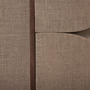 Close-up of a textured beige fabric surface with a dark brown seam. - Number 4