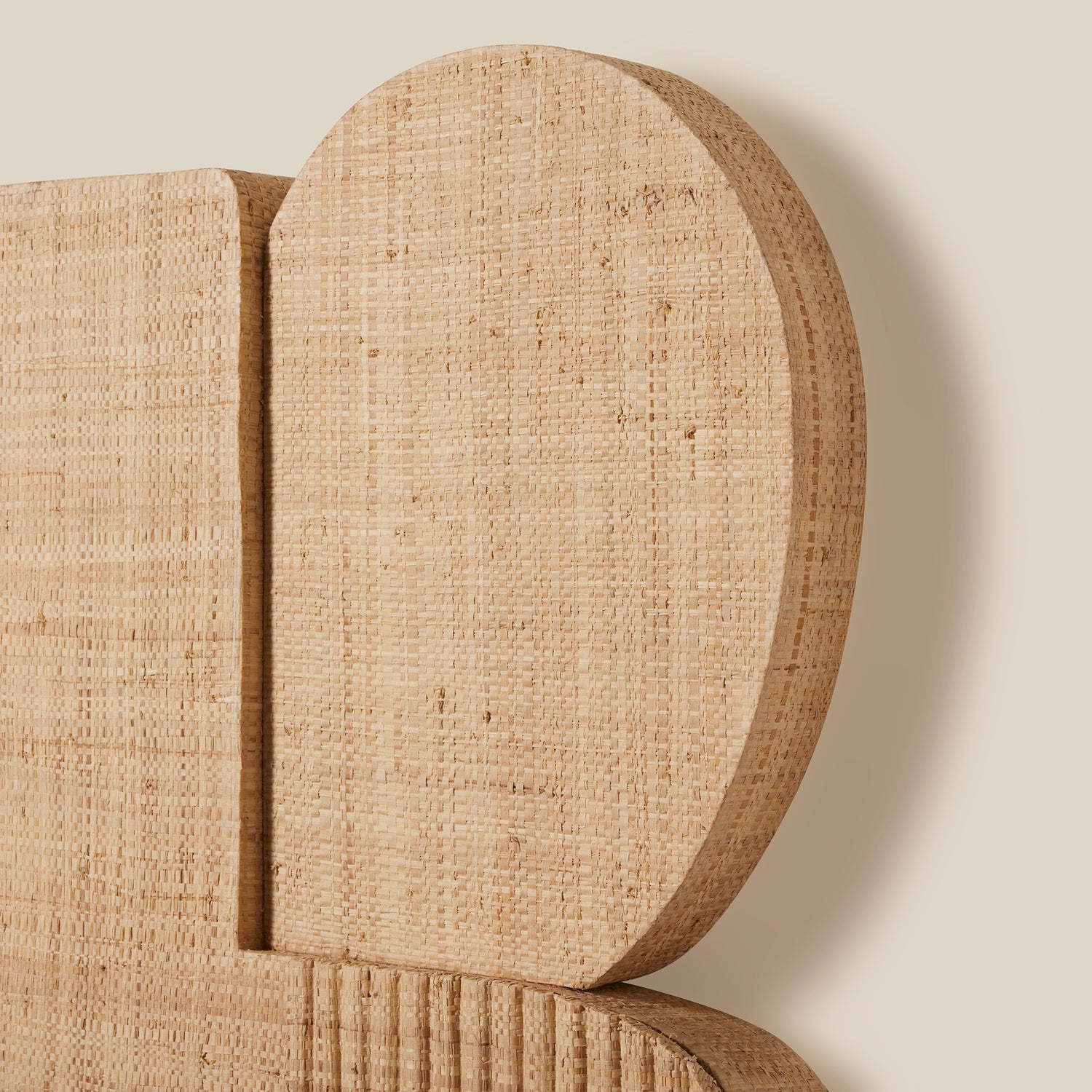 Close-up of a textured beige headboard against a plain background- Number 4