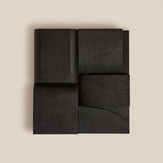 Black fabric wall art on a beige background