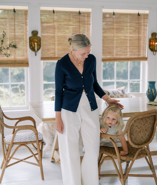 woman and child in kitchen with white floors and brown chairs