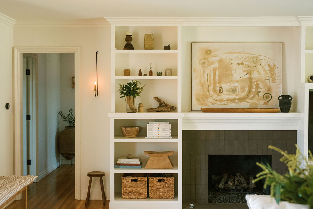 room with fireplace, painting, and shelves