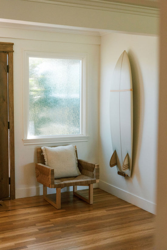 chair next to hanging surfboard