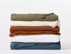Stack of folded shirts in various colors on a white background - Number 5