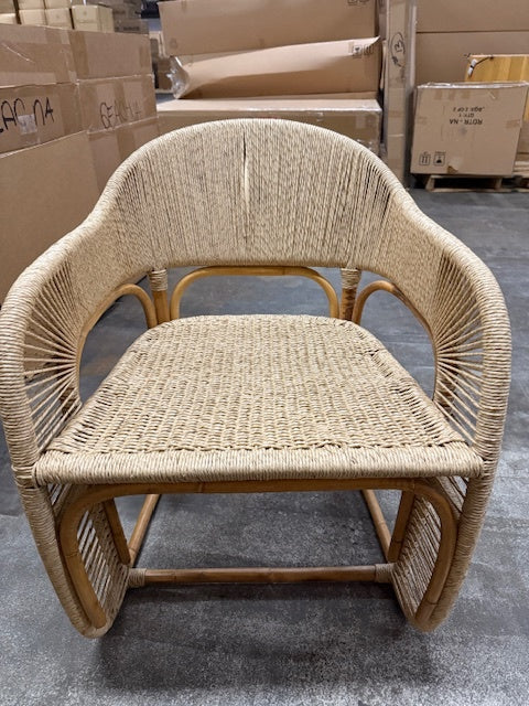 Wicker chair in a warehouse setting with cardboard boxes in the background- Number 2