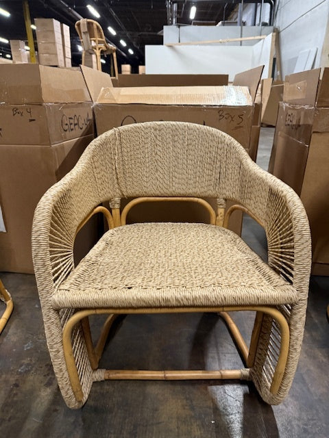 Woven chair in a warehouse setting with cardboard boxes in the background- Number 2