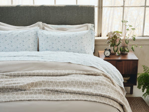 Neatly made bed with light-colored bedding in a bright bedroom. - Number 3